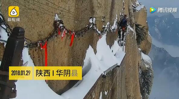 华山扫雪惊险现场 清洁工在峭壁边上“扫雪”背后就是万丈深渊